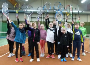 14 Bambini Tennisspieler stehen auf dem Tennisplatz in der Halle des SportForum Bernau und halten ihre Schläger hoch
